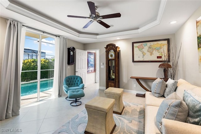 living area featuring ceiling fan, a raised ceiling, and light tile patterned floors