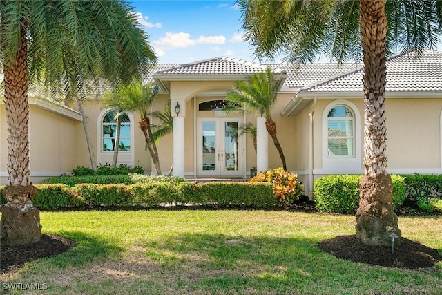 doorway to property with french doors and a lawn