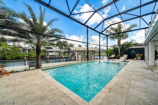 view of pool with glass enclosure, a patio area, a water view, and pool water feature