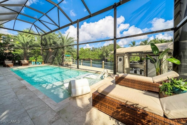 view of swimming pool featuring outdoor lounge area, pool water feature, a patio area, and a lanai