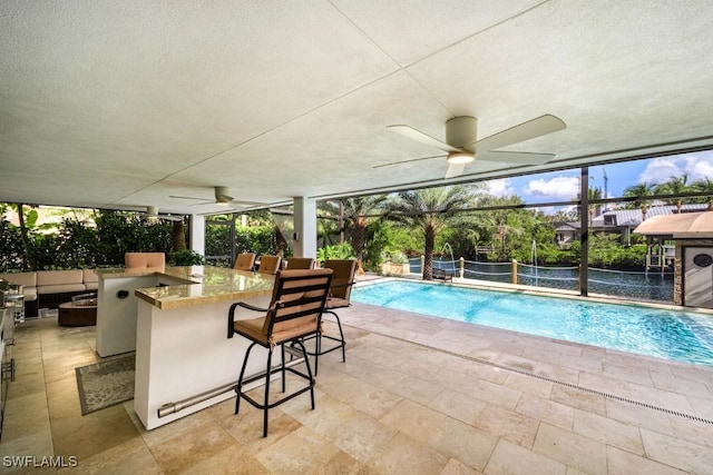 view of swimming pool featuring pool water feature, an outdoor bar, and a patio