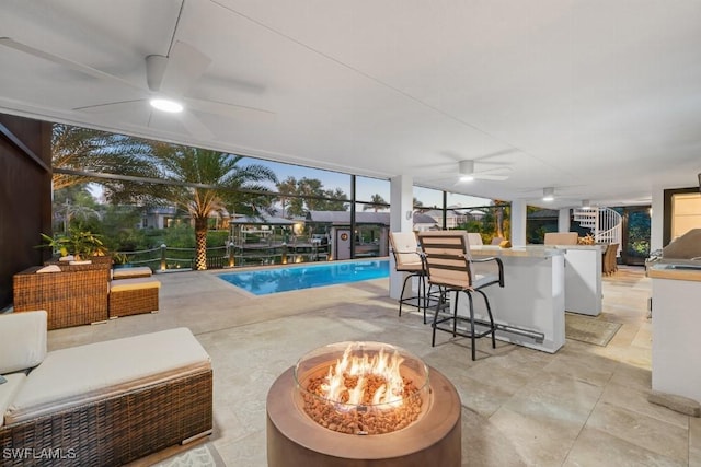 view of pool with an outdoor living space with a fire pit, a patio area, ceiling fan, and an outdoor bar