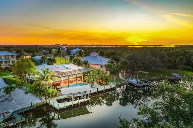 aerial view at dusk featuring a water view