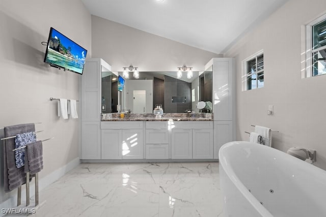 bathroom with vanity, a bath, and lofted ceiling