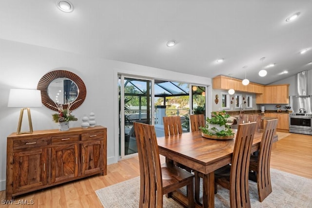 dining area featuring light hardwood / wood-style floors and lofted ceiling