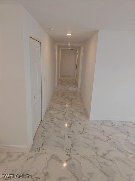 corridor featuring recessed lighting, marble finish floor, and baseboards