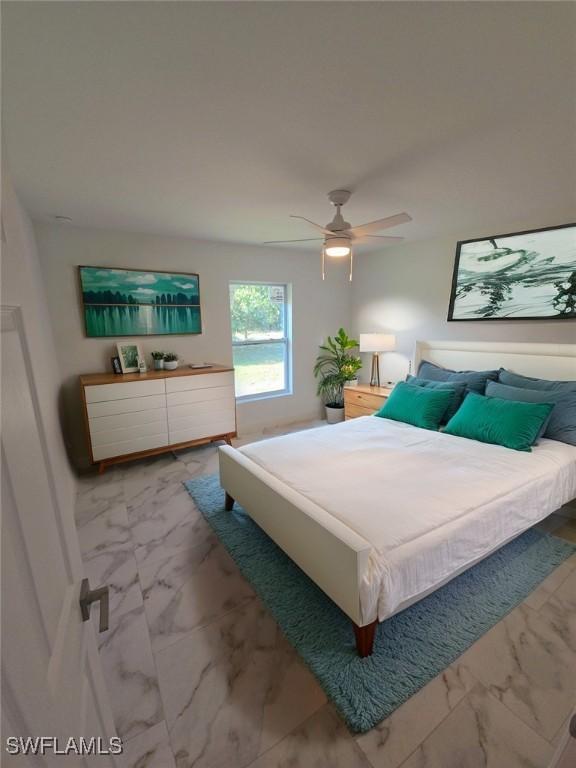 bedroom featuring marble finish floor and ceiling fan