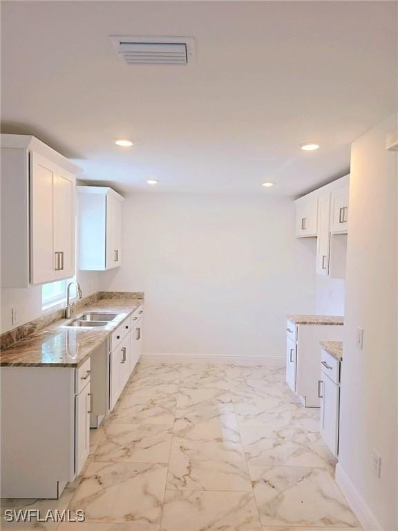 kitchen featuring white cabinetry, sink, and stone counters