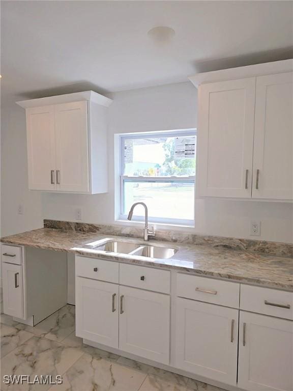 kitchen featuring white cabinetry and sink