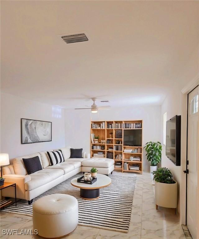 living area featuring marble finish floor, visible vents, and a ceiling fan