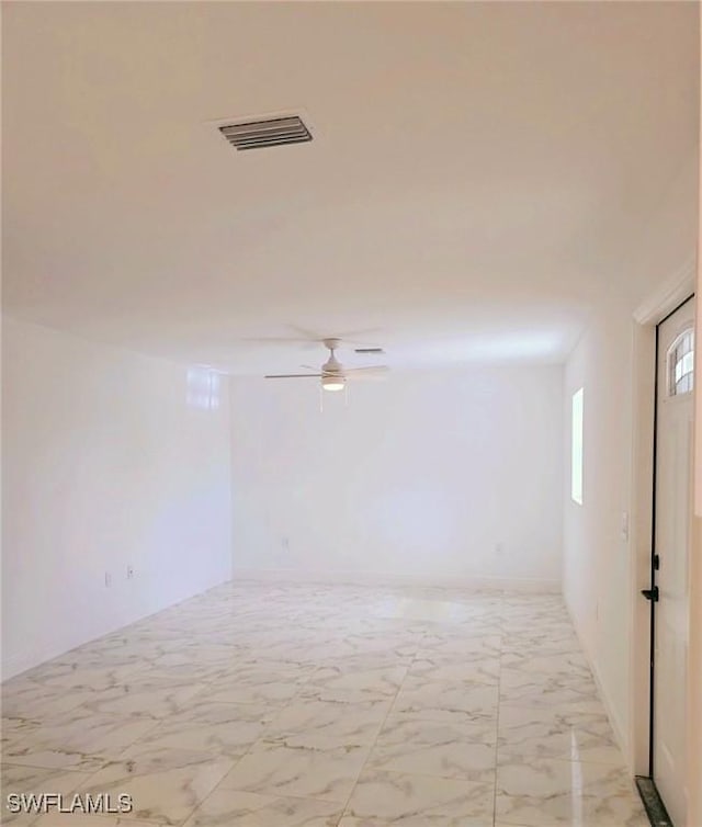 empty room with marble finish floor, visible vents, and ceiling fan