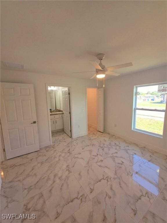 unfurnished bedroom with ceiling fan, marble finish floor, connected bathroom, and baseboards