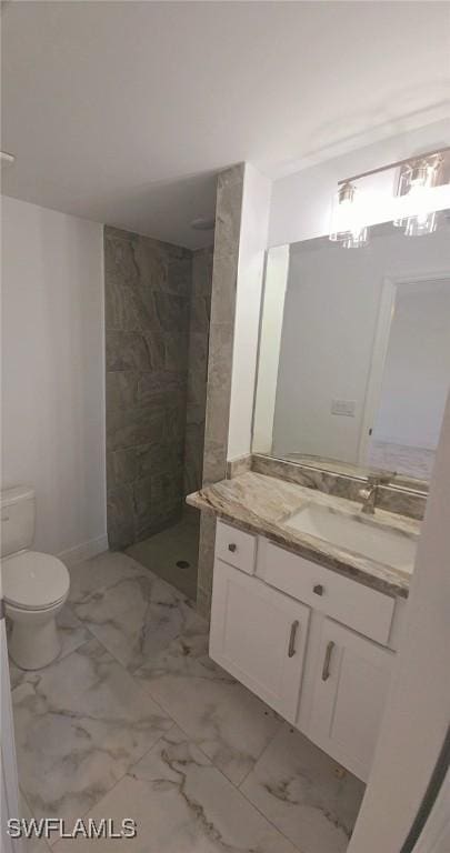 bathroom featuring toilet, marble finish floor, a walk in shower, and vanity