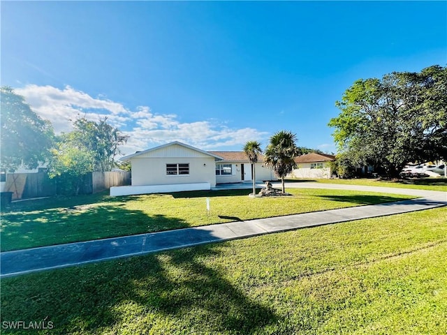 view of front of home with fence and a front lawn