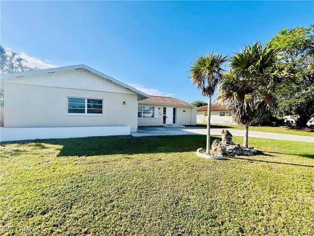 rear view of property with a lawn and a patio