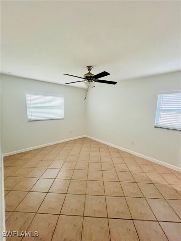 tiled empty room featuring ceiling fan