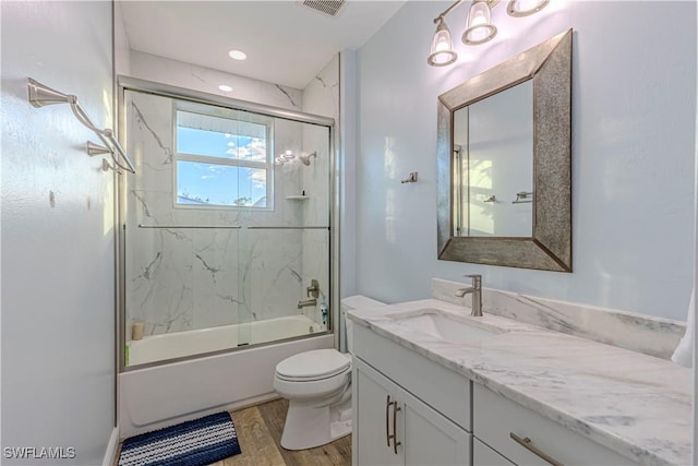 full bathroom featuring enclosed tub / shower combo, toilet, wood-type flooring, and vanity