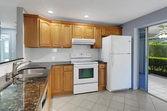 kitchen with white appliances, dark stone counters, sink, ceiling fan, and light tile patterned flooring