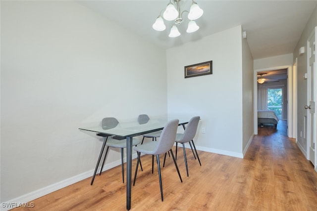 dining space with a notable chandelier and light hardwood / wood-style flooring