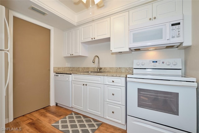 kitchen with white appliances, sink, and white cabinets