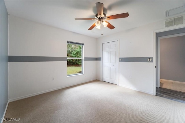 carpeted spare room with ceiling fan