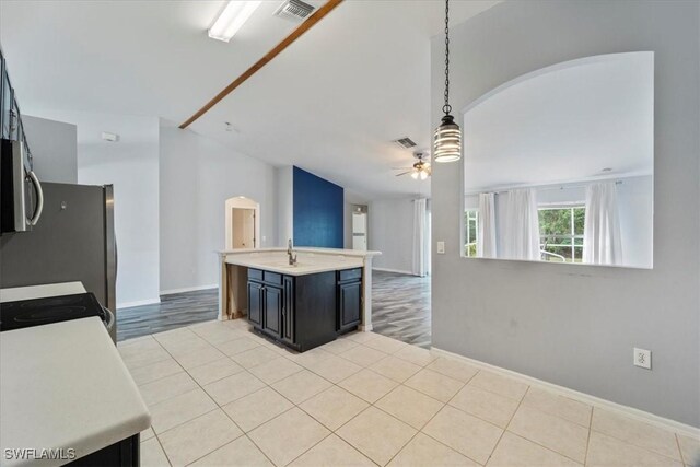 kitchen with ceiling fan, sink, hanging light fixtures, and light hardwood / wood-style flooring