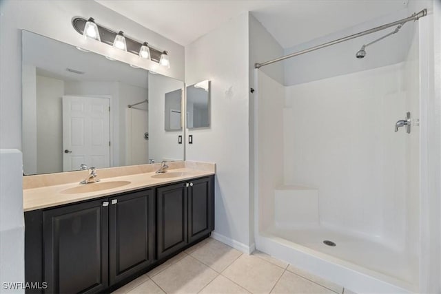 bathroom with tile patterned flooring, vanity, and walk in shower