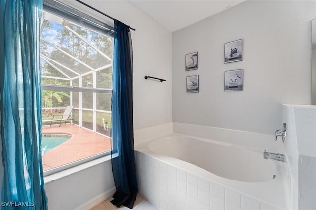 bathroom featuring tile patterned floors, a healthy amount of sunlight, and tiled tub