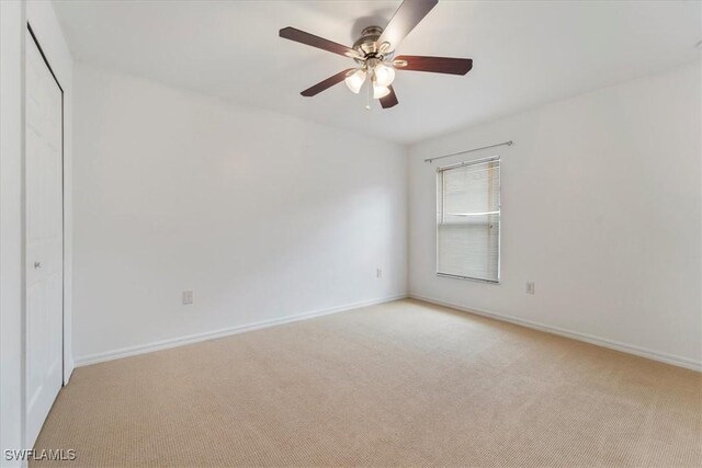 unfurnished bedroom with ceiling fan and light colored carpet