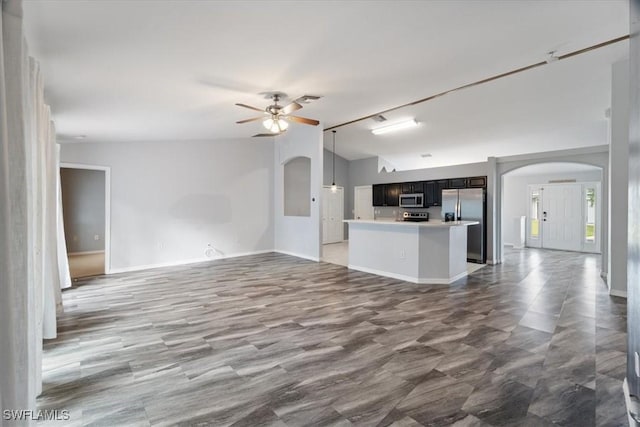 unfurnished living room featuring ceiling fan and vaulted ceiling