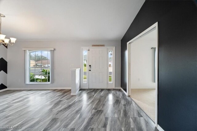 entryway featuring a chandelier and vaulted ceiling