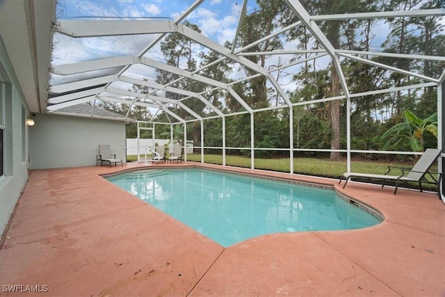 view of pool with glass enclosure and a patio