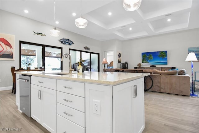 kitchen with light hardwood / wood-style floors, sink, white cabinetry, and a kitchen island with sink