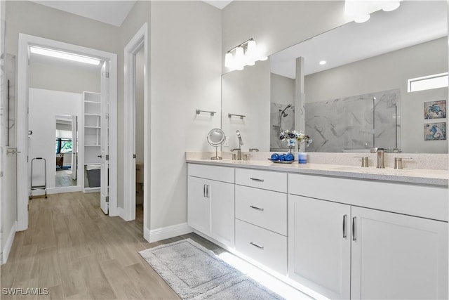 bathroom featuring hardwood / wood-style floors, vanity, and walk in shower