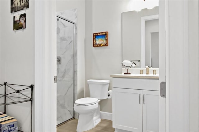 bathroom featuring vanity, hardwood / wood-style flooring, toilet, and a shower with shower door