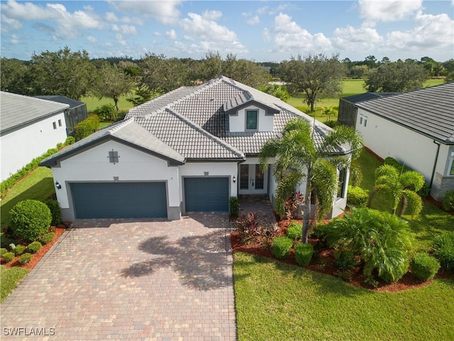 view of front of house featuring french doors, a front yard, and a garage