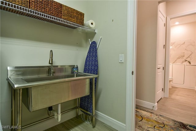 clothes washing area with light hardwood / wood-style floors