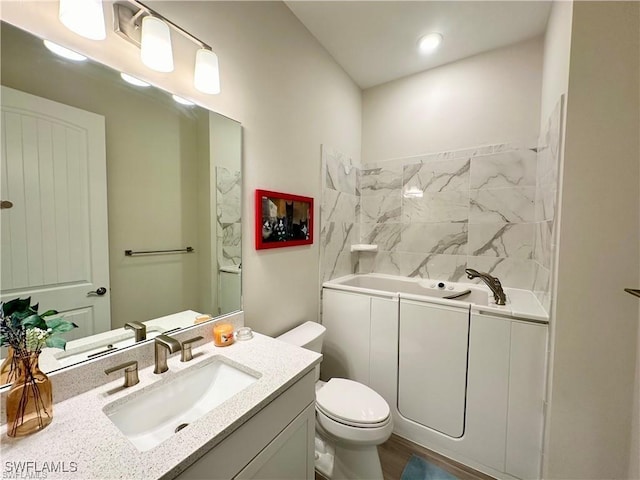 bathroom with wood-type flooring, vanity, toilet, and a bathing tub