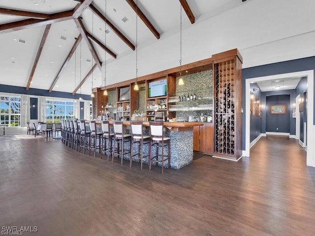 bar with beam ceiling, high vaulted ceiling, pendant lighting, and dark hardwood / wood-style floors