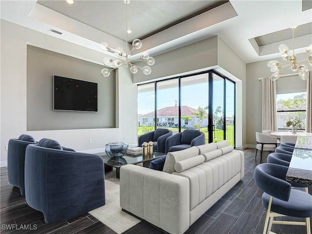 living room featuring a tray ceiling and a chandelier