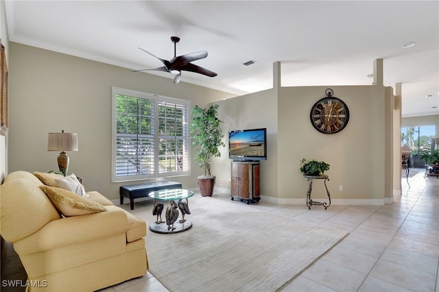 tiled living room with crown molding, ceiling fan, and a healthy amount of sunlight