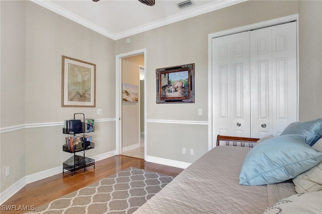 bedroom featuring wood-type flooring, a closet, crown molding, and ceiling fan