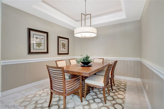 tiled dining area featuring a tray ceiling