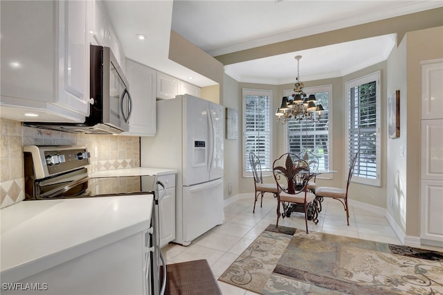 kitchen with white cabinets, stainless steel appliances, light tile patterned floors, and an inviting chandelier