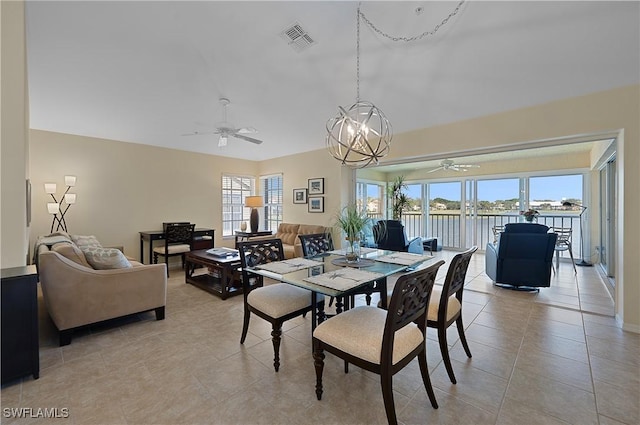 dining area featuring ceiling fan with notable chandelier, plenty of natural light, and light tile patterned flooring