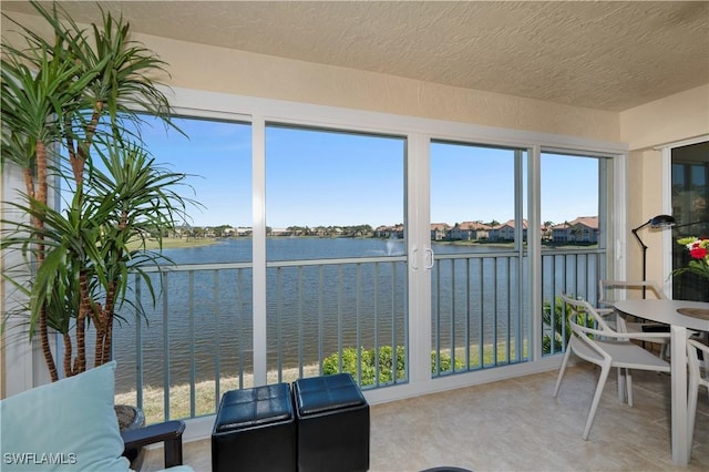 sunroom featuring a water view