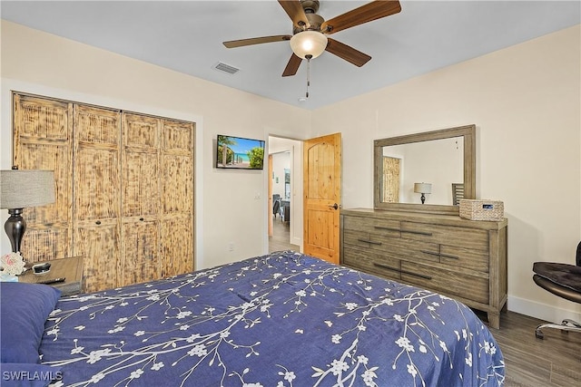 bedroom with ceiling fan, dark hardwood / wood-style floors, and a closet