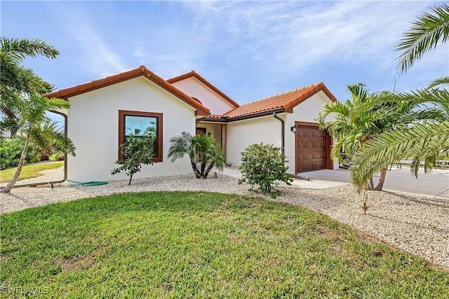 mediterranean / spanish-style home with a garage and a front lawn