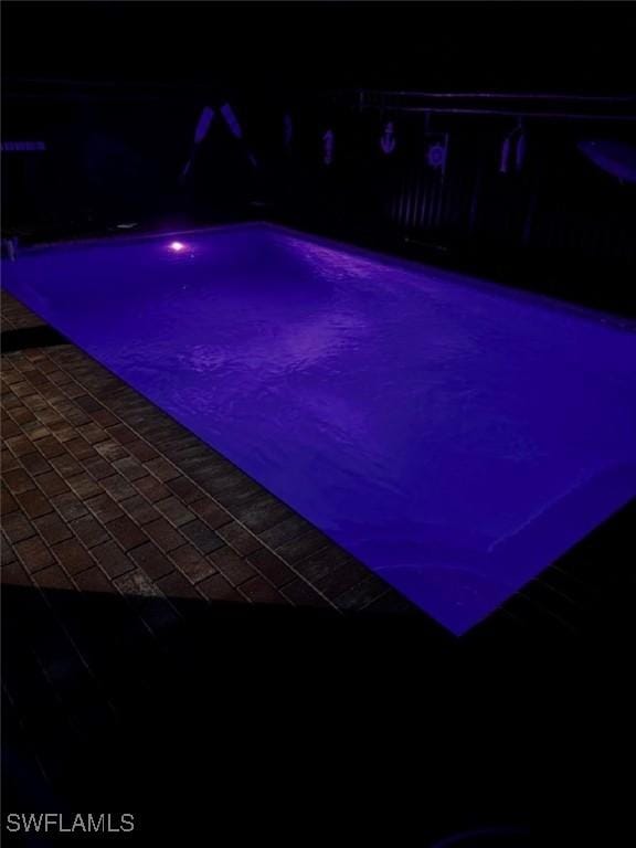 pool at night with a patio area