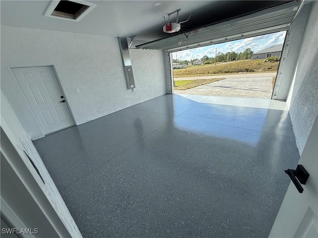 garage featuring electric panel and a garage door opener